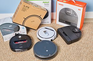 Four robot vacuums on the floor for the pet hair vacuum test