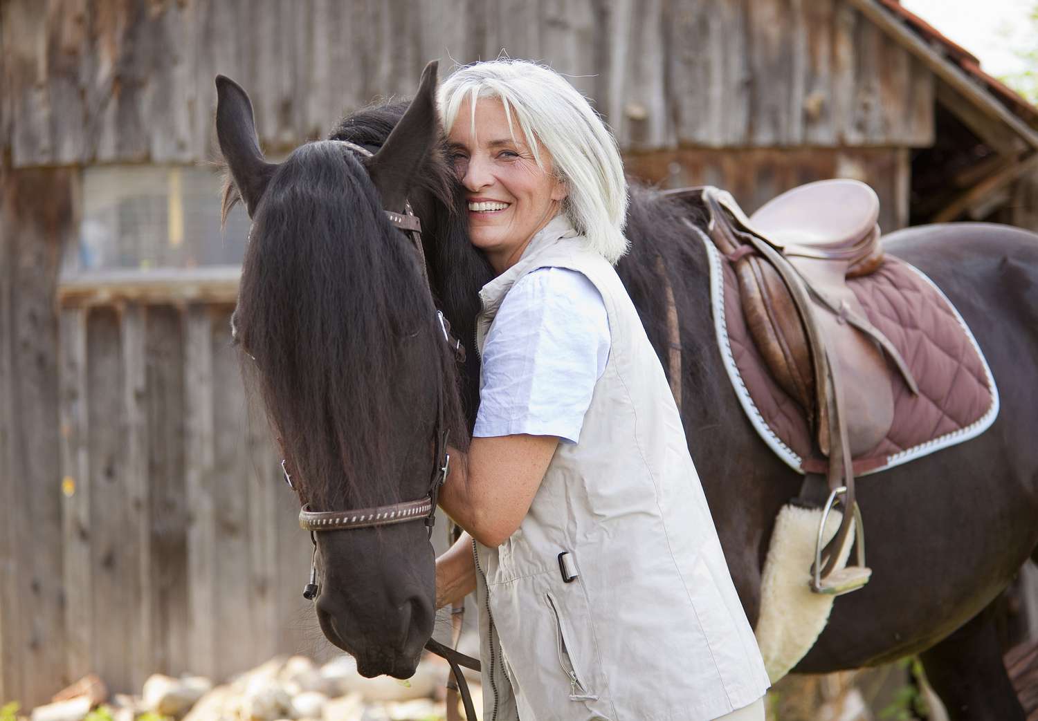 Mature woman hugging horse.