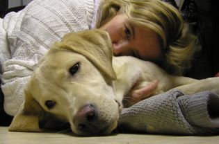 A woman cuddling with a dog