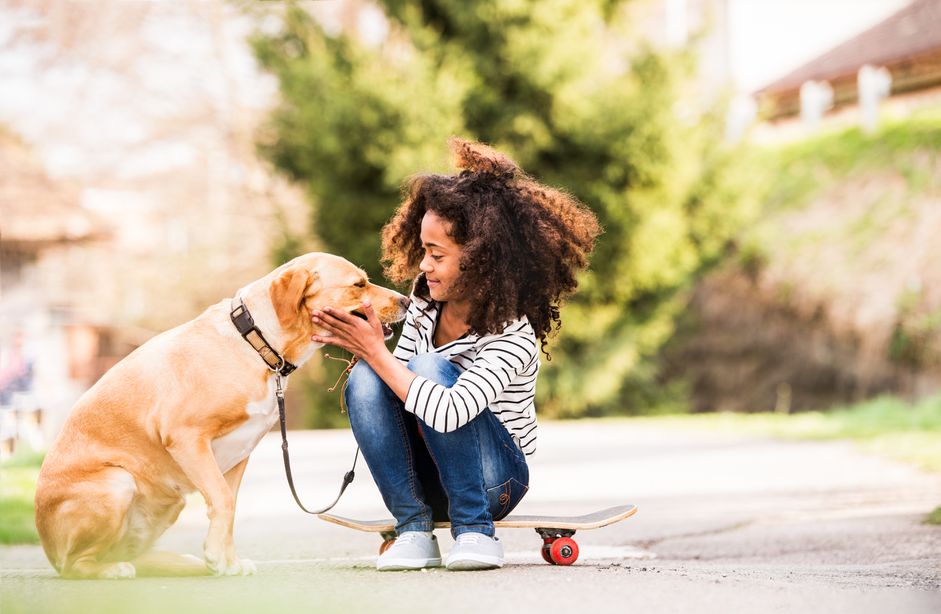 Girl outdoors on skateboard with her dog